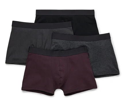 Vier Herren Boxershorts in Schwarz, Grau und Burgunder liegen übereinander.
