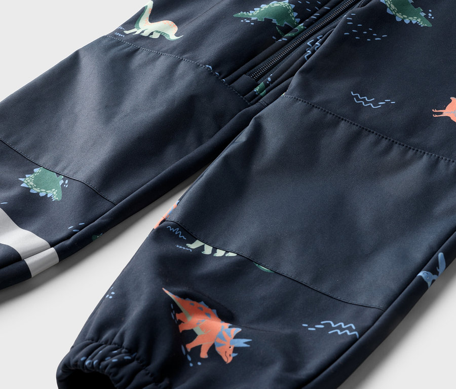 Nahaufnahme einer marineblauen Hose mit Dinosaurier-Muster, Reißverschluss oben und weißem Streifen am Bein.