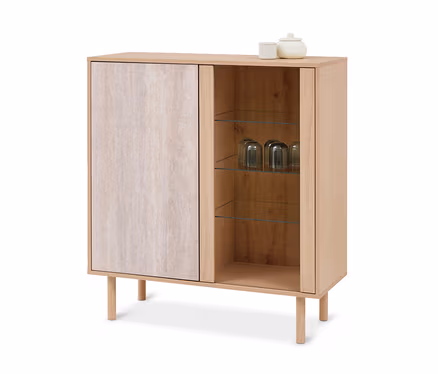 Helles Holzregal mit zwei Fächern; links eine geschlossene Tür mit heller, strukturierter Oberfläche, rechts offene Glasböden mit drei umgedrehten Gläsern. Oben stehen eine weiße Tasse und ein weißes Gefäß mit Deckel.