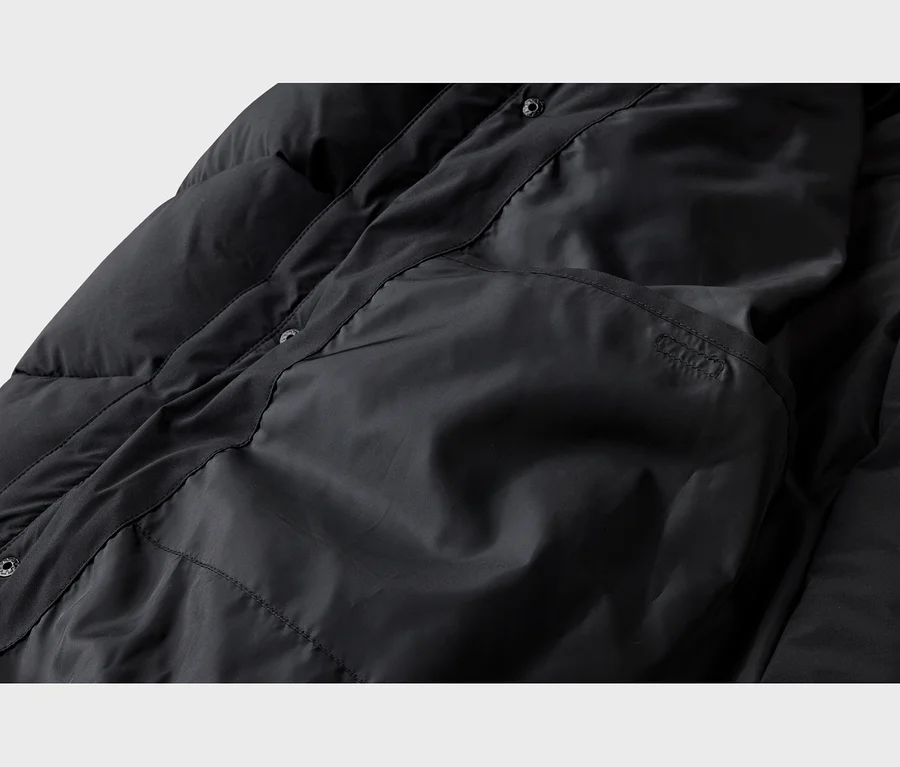 Schwarze Steppjacke von innen mit gestepptem Futter, Innentasche und Druckknöpfen.