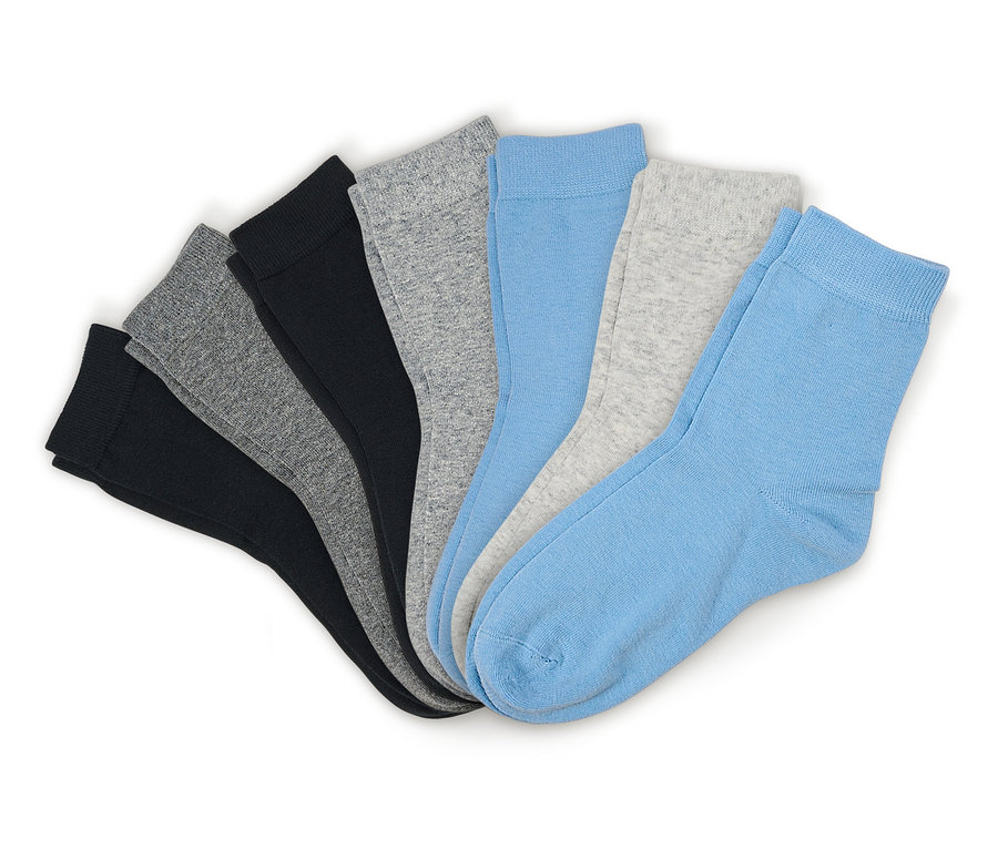 Sieben Socken in Schwarz, Grau und Hellblau, fächerförmig auf weißem Hintergrund ausgebreitet.