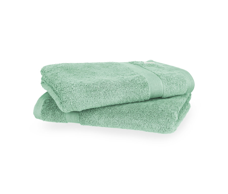 Zwei salbeigrüne Badetücher der SCHÖNER WOHNEN-Kollektion „Cuddly“, gefaltet und übereinandergelegt.