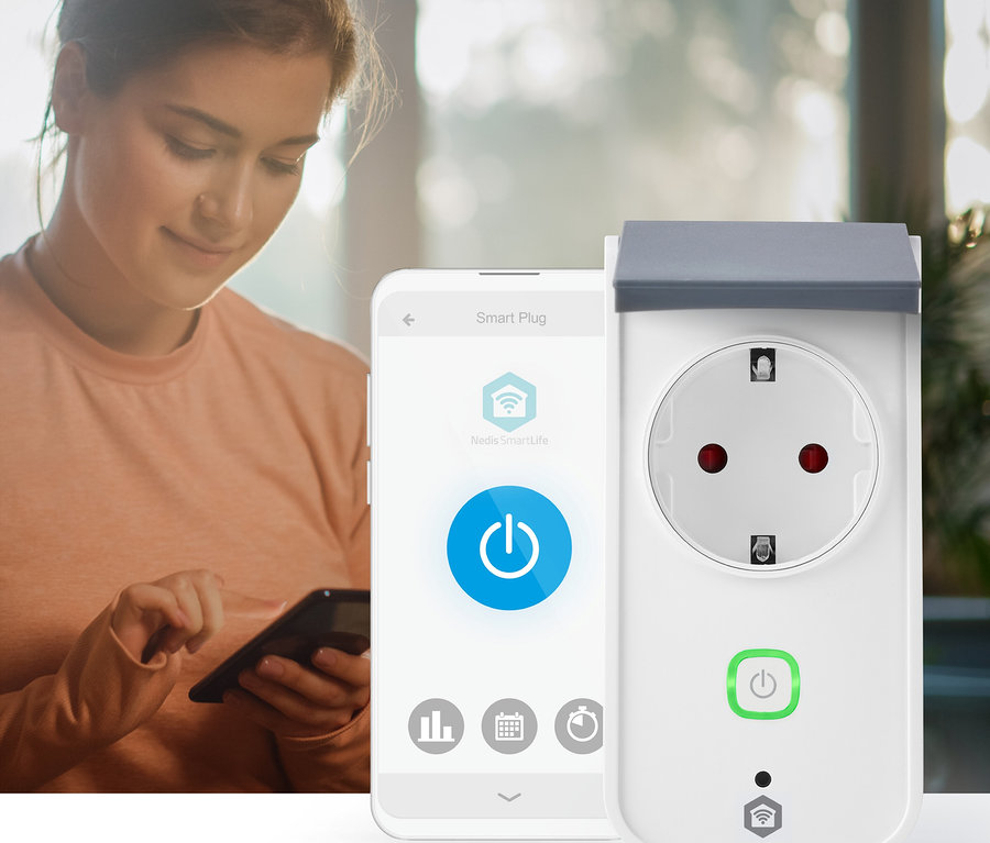 Eine Frau im Hintergrund blickt auf ihr Smartphone, das im Vordergrund neben einem weißen Smart Plug zu sehen ist. Der Telefonbildschirm zeigt eine "Smart Plug"-App mit einem großen blauen Ein-/Ausschalter, und der Smart Plug hat einen grünen Ein-/Ausschalter und eine graue Abdeckung.