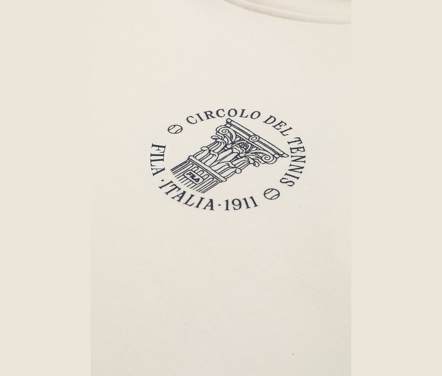 Detailansicht eines off-white FILA Damen-Hoodies mit einem runden, dunkelblauen Logo. Das Logo zeigt eine klassische Säule mit der Aufschrift „FILA“, umgeben von den Texten „CIRCOLO DEL TENNIS“ und „FILA ITALIA 1911“ sowie zwei Tennisball-Symbolen.