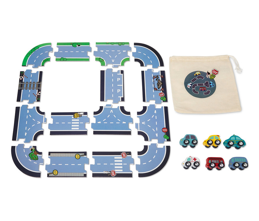 Ein Auto-Spiel-Set mit Spielstraße zum Legen ist auf dem Boden ausgebreitet, daneben liegen ein Stoffbeutel und kleine Autos.