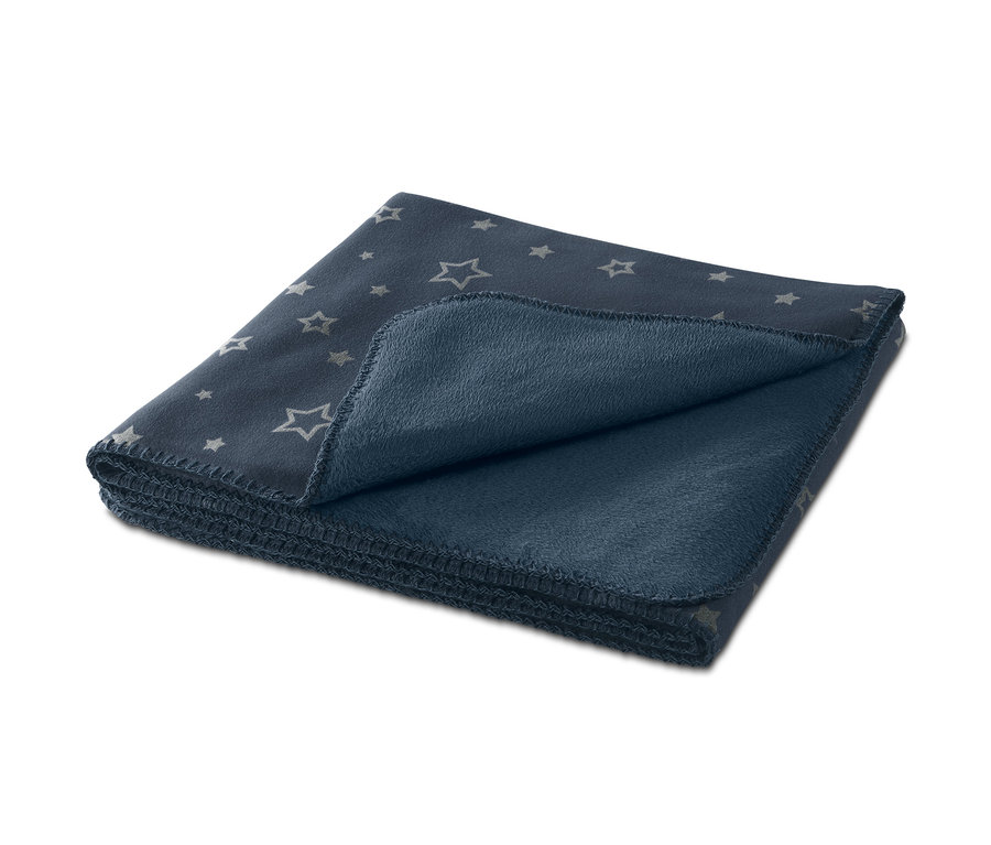 Zusammengelegte Kuscheldecke mit Leuchteffekt und Sternenmuster.