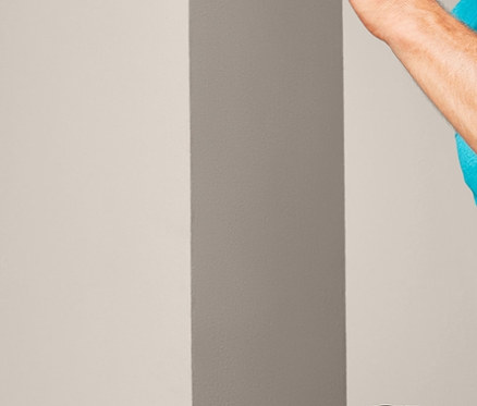 Mann im türkisfarbenen T-Shirt und Sportshorts hebt sein Knie.