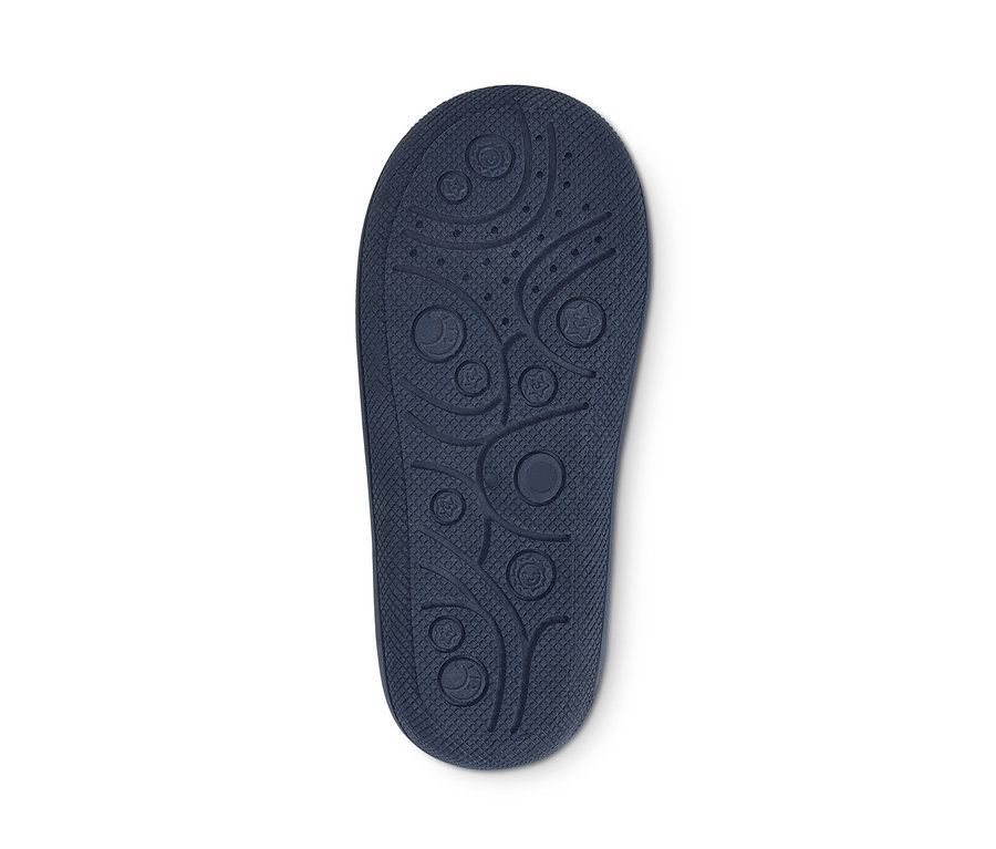 Detailaufnahme der Sohle eines Hausschuhs mit Reliefmuster auf weissem Hintergrund.