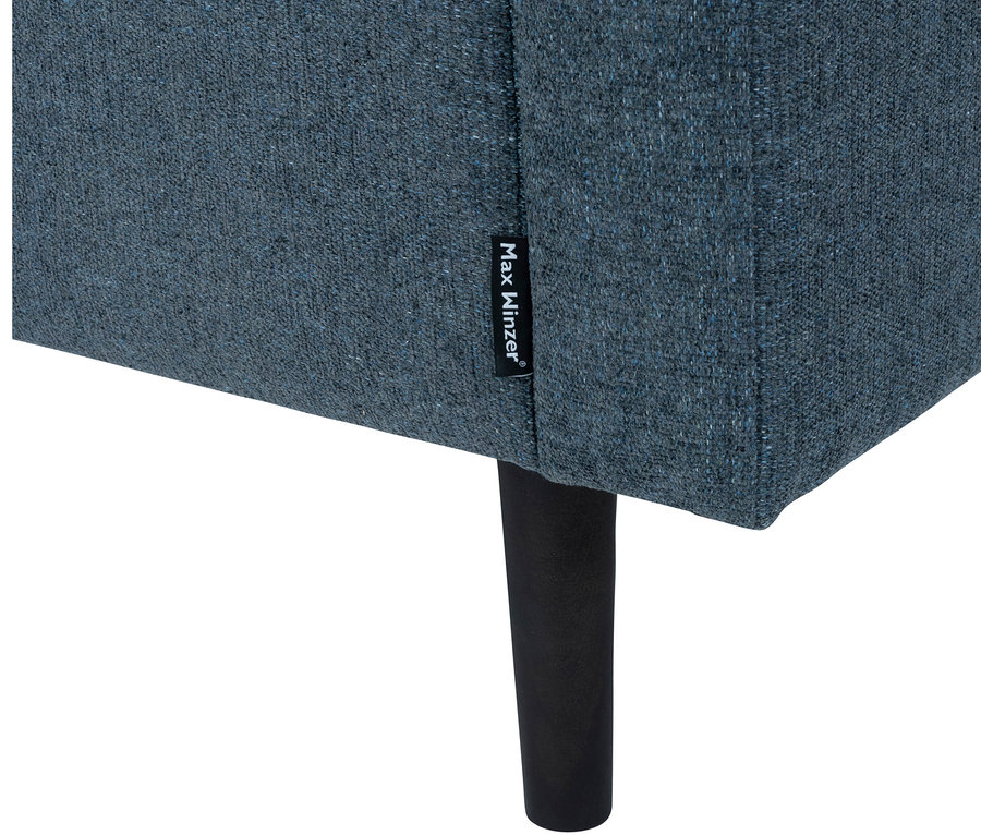 Detailaufnahme eines blauen Kindersofas »Orion« mit schwarzen Beinen und Max Winzer Etikett.