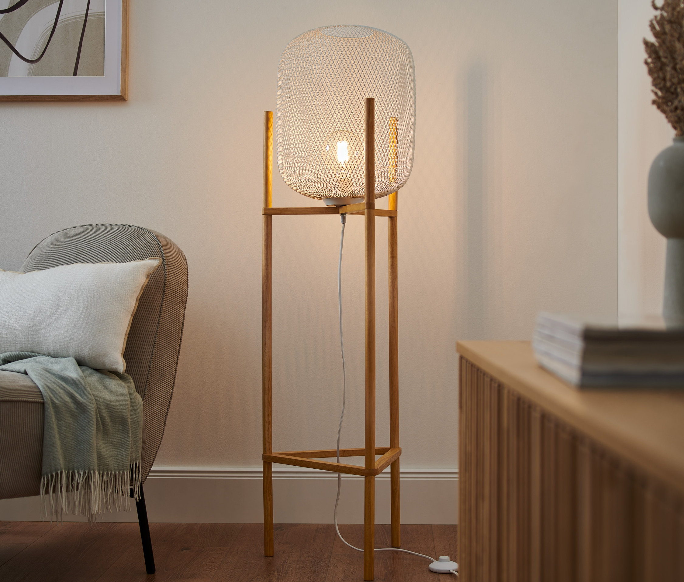 Im Wohnzimmer steht eine Dreibein-Stehleuchte.