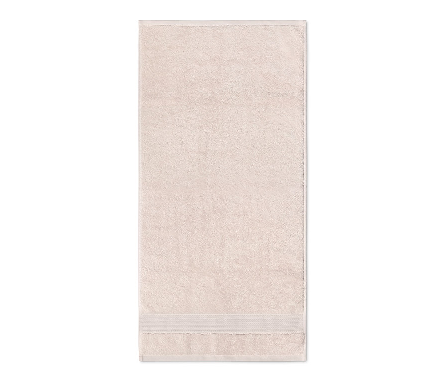 Ein beigefarbenes Badetuch mit Kordelborte liegt.