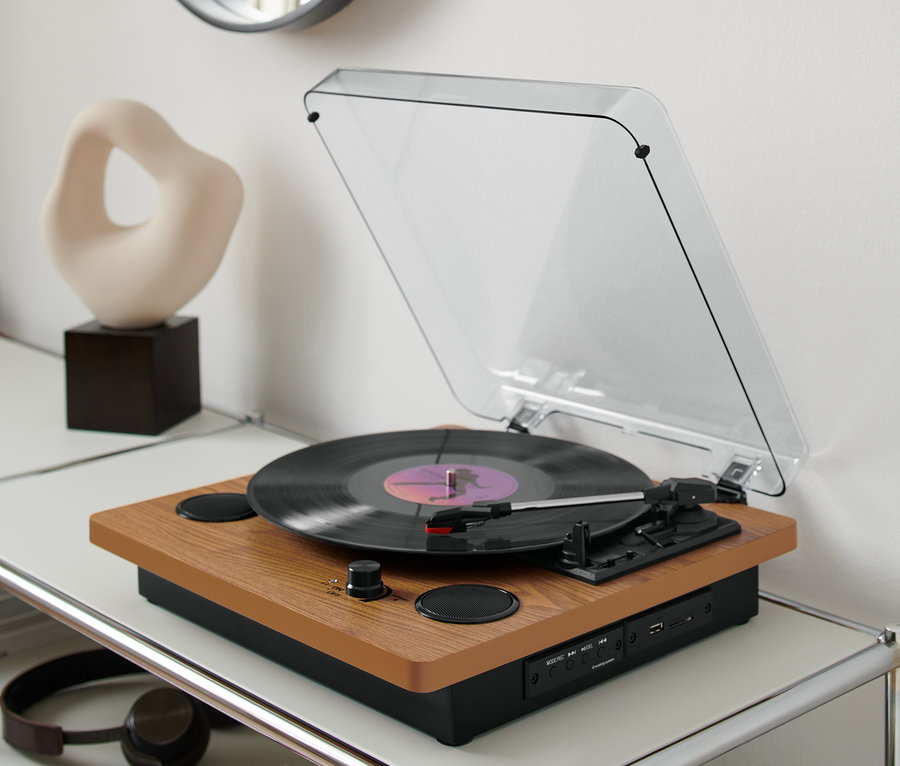 Schallplattenspieler »Dual DTR 61« mit eingebauten Lautsprechern auf einem weißen Tisch mit Schallplatten.