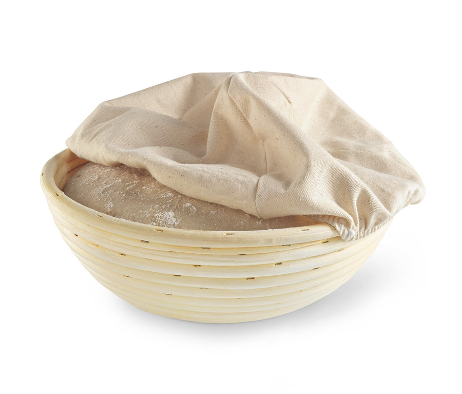 Ein rundes Gärkörbchen mit Teig und Stoffbezug.