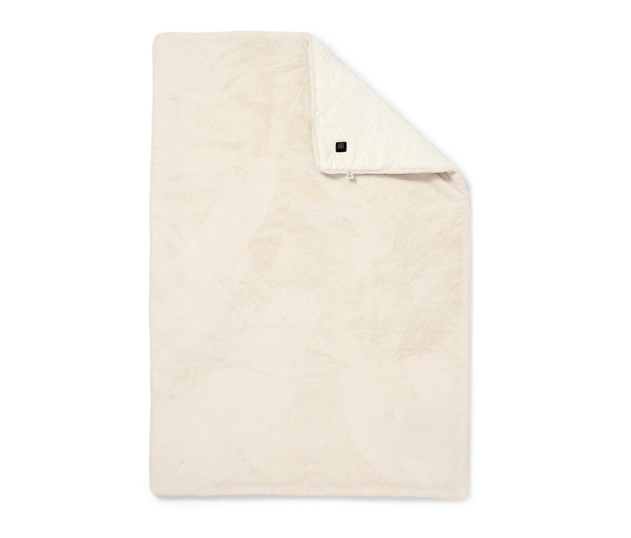 Ein zusammengelegter, beige-farbener Akku-Heizponcho auf einem weißen Hintergrund.