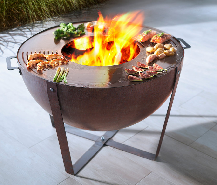Buschbeck Plancha-Grill »Dakota« mit Speisen und Feuer in der Mitte.