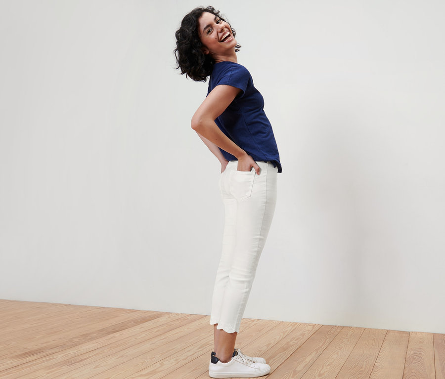 Frau posiert in 7/8-Treggings mit Lochstickerei und blauem T-Shirt.