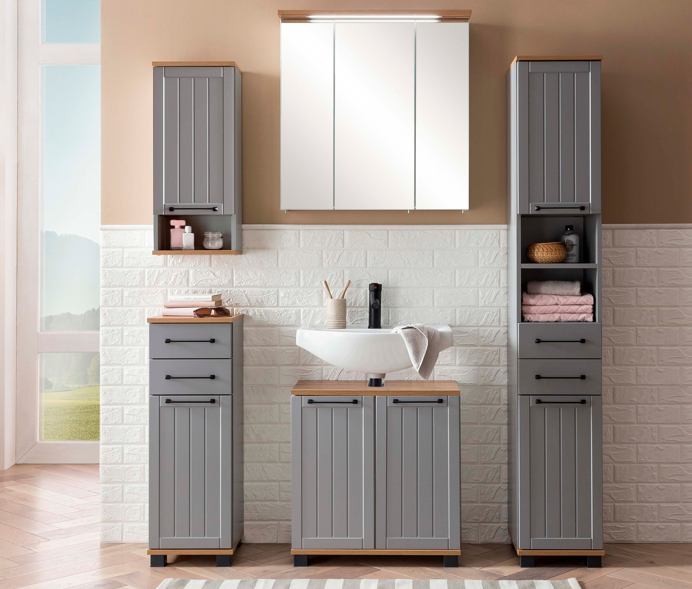 Badezimmer mit Hochschrank, Unterschrank, Hängeschrank und Waschbeckenunterschrank »Jelda« in platingrau und Eiche-Dekor.