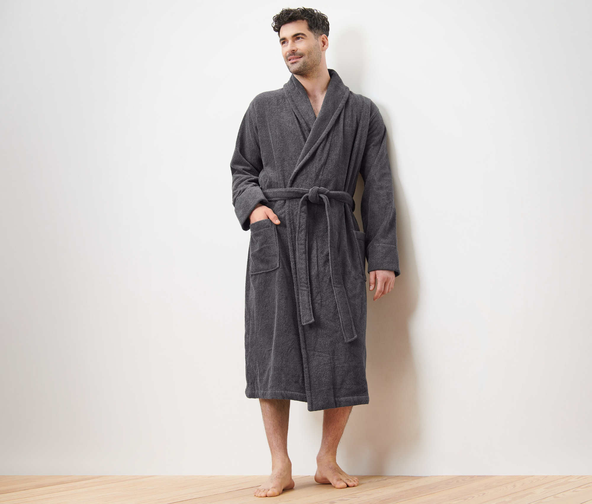 Mann steht und trägt einen grauen Herren-Bademantel.