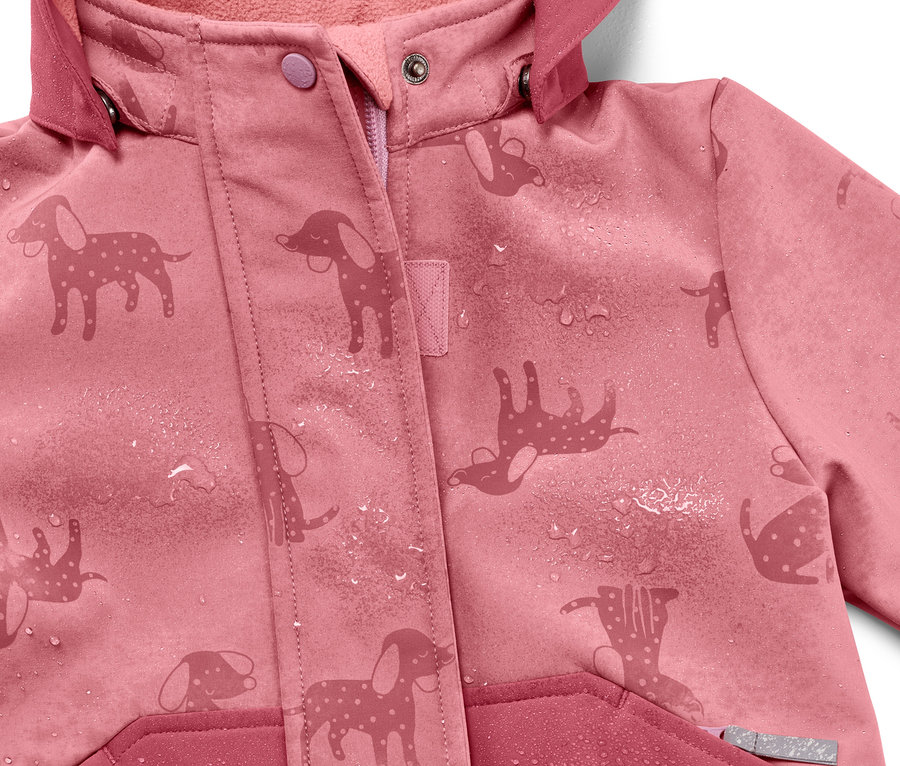 Detailansicht einer rosa Kinder-Softshelljacke mit Hundemuster, die bei Regen die Farbe wechselt, mit Wassertropfen.