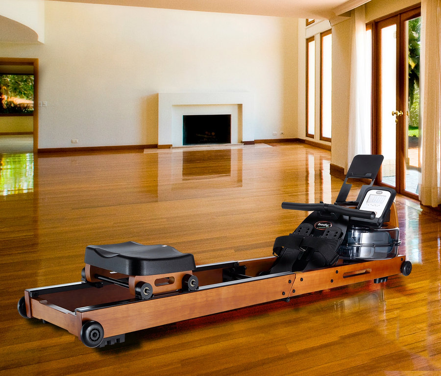 Bodycoach Wasser Rudergerät »Wood Compact« steht auf glänzendem Holzboden im Wohnzimmer.