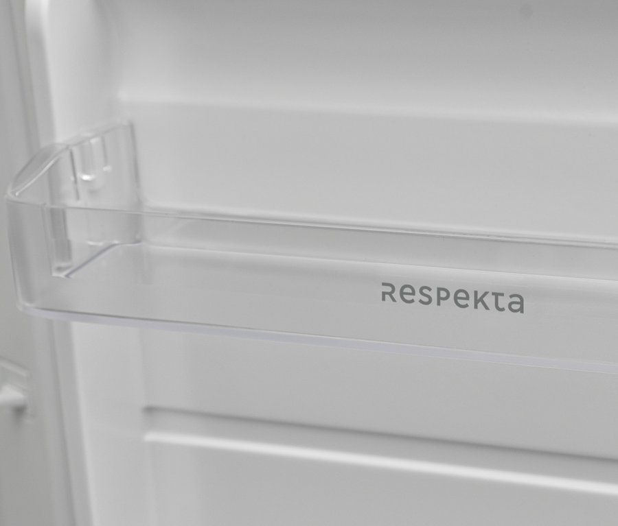 Detailaufnahme des Innenraums eines Kühlschranks mit einem transparenten Fach mit dem Schriftzug Respekta.