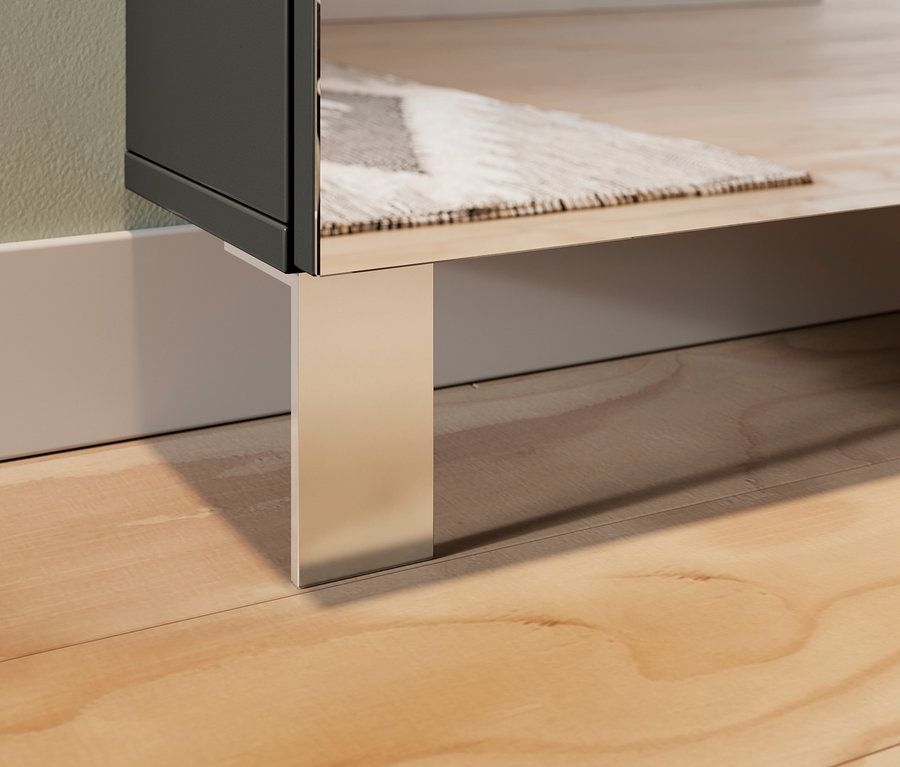 Detailaufnahme eines Schuhschranks mit Spiegel und einem verchromten Bein auf einem Holzboden.