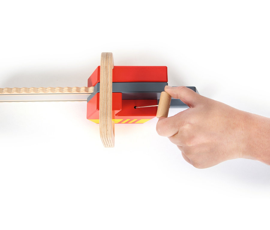 Eine Hand bedient die rot-graue small foot Kettensäge mit Holzrad und Säge.