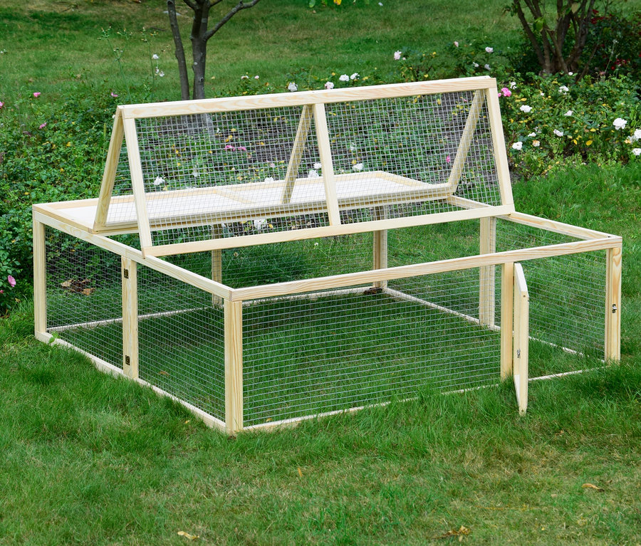 Ein Dobar Freilaufgehege aus Holz mit Drahtgeflecht steht auf einer Wiese.