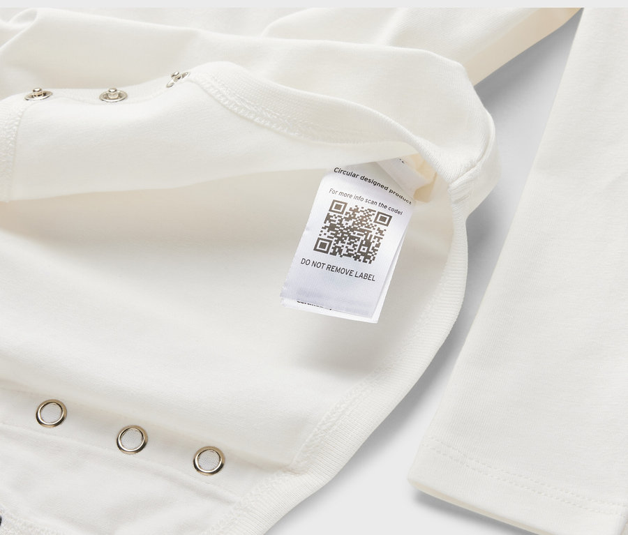 Detailansicht eines weißen 5er-Baby-Bodys mit Mitwachsfunktion und langem Ärmel, mit einem Etikett mit QR-Code.