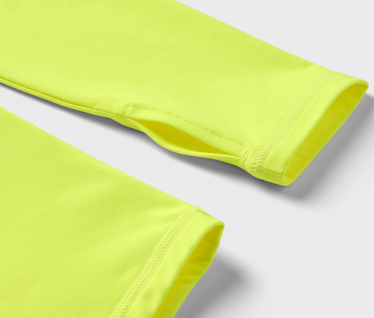 Detailaufnahme eines neon-gelben langärmligen Shirts mit Daumenloch.