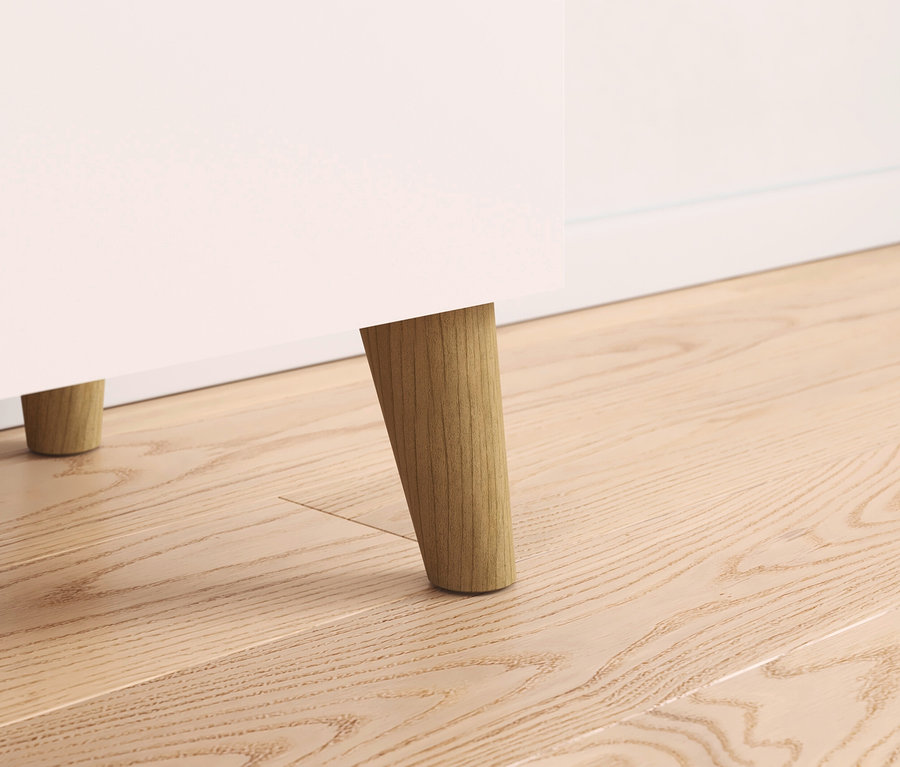 Detailaufnahme von Möbelbeinen aus Holz auf einem Holzboden.