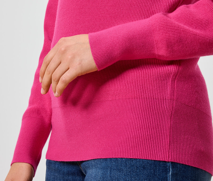 Detailansicht eines pinken Damenpullovers und blauen Jeans.