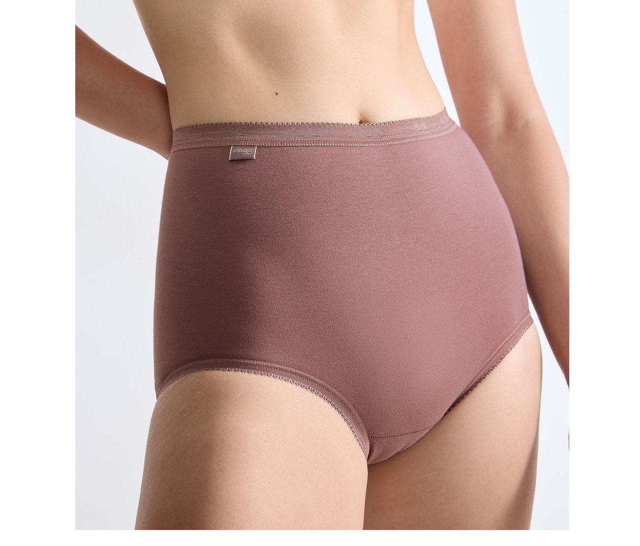 Eine Person trägt eine hochgeschnittene sloggi Basic+ Maxi C3P Unterhose in Kakaobraun mit geripptem Bund.
