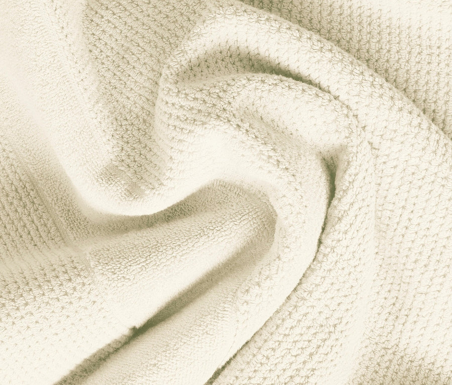 Detailaufnahme eines cremefarbenen Frotteehandtuchs.