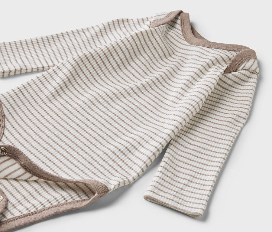 Ein langärmliger Body aus einem 3-teiligen Baby-Set liegt flach und ist braun-weiß gestreift.