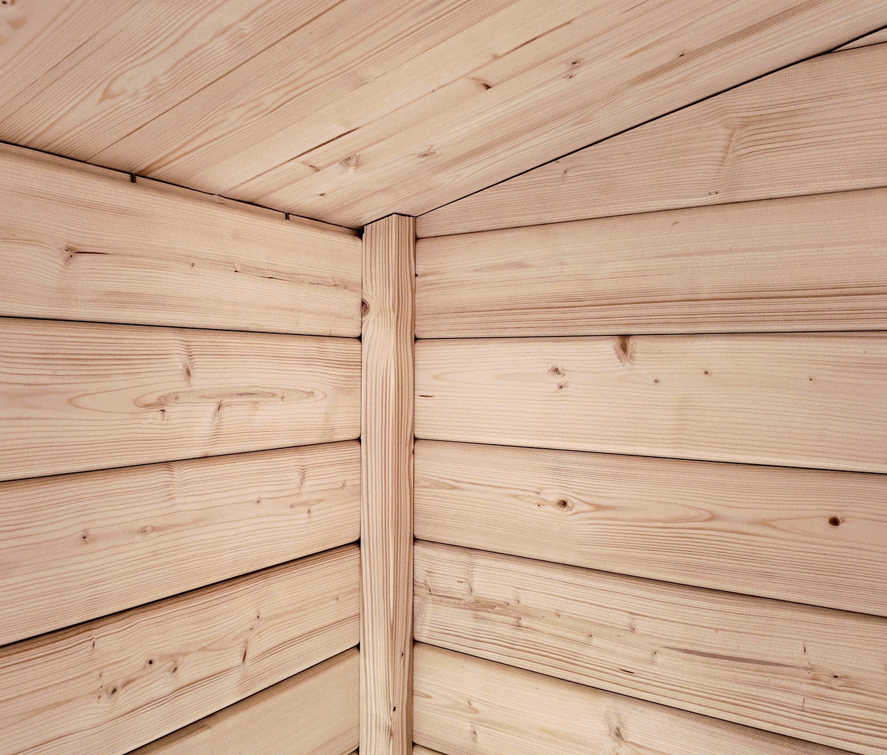 Eckansicht einer Holzwand und Decke mit hellen Holzbrettern.