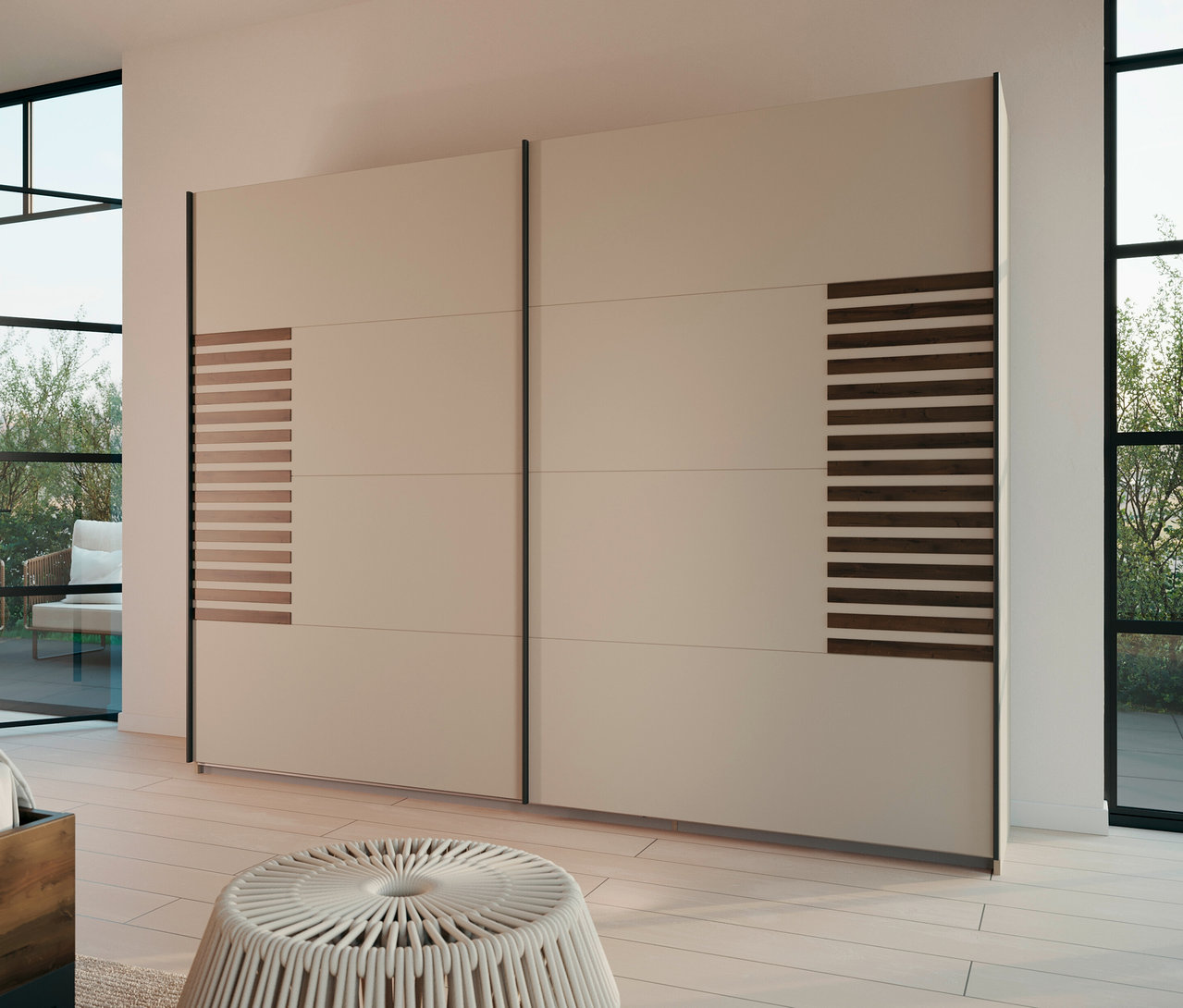 Beiger Schiebetürenschrank mit horizontalen Holzpaneelen steht in einem hellen Raum mit Fenster und einem weißen Hocker.