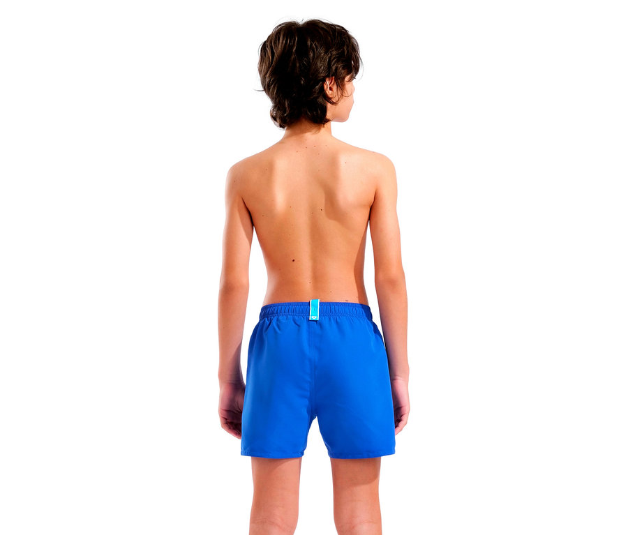 Rückansicht eines Jungen mit braunen Haaren, der blaue Badeshorts vor einem weißen Hintergrund trägt.