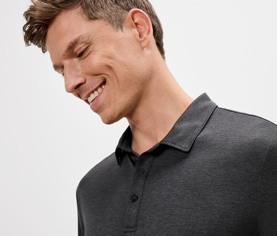 Lächelnder Mann mit grauem Poloshirt.