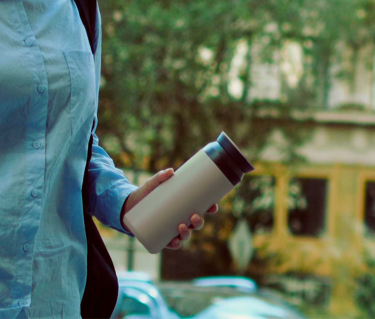 Frau hält eine beige Thermoskanne.