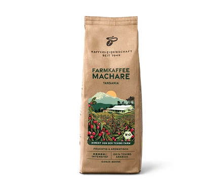 Braune Papiertüte Farmkaffee Machare – 500 g Ganze Bohne, mit einer Illustration einer Kaffeeplantage mit roten Kirschen, einem weißen Haus und einem Berg. Text: „Tansania“, „Fruchtig & Aromatisch“, „100% Tchibo Arabica“.
