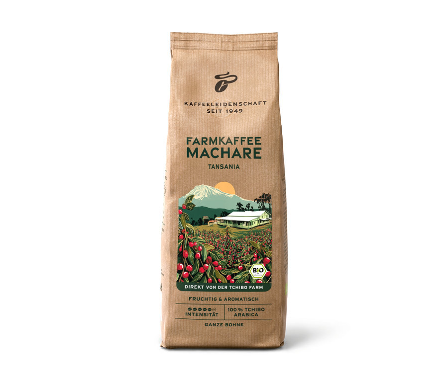 Braune Papiertüte Farmkaffee Machare – 500 g Ganze Bohne, mit einer Illustration einer Kaffeeplantage mit roten Kirschen, einem weißen Haus und einem Berg. Text: „Tansania“, „Fruchtig & Aromatisch“, „100% Tchibo Arabica“.