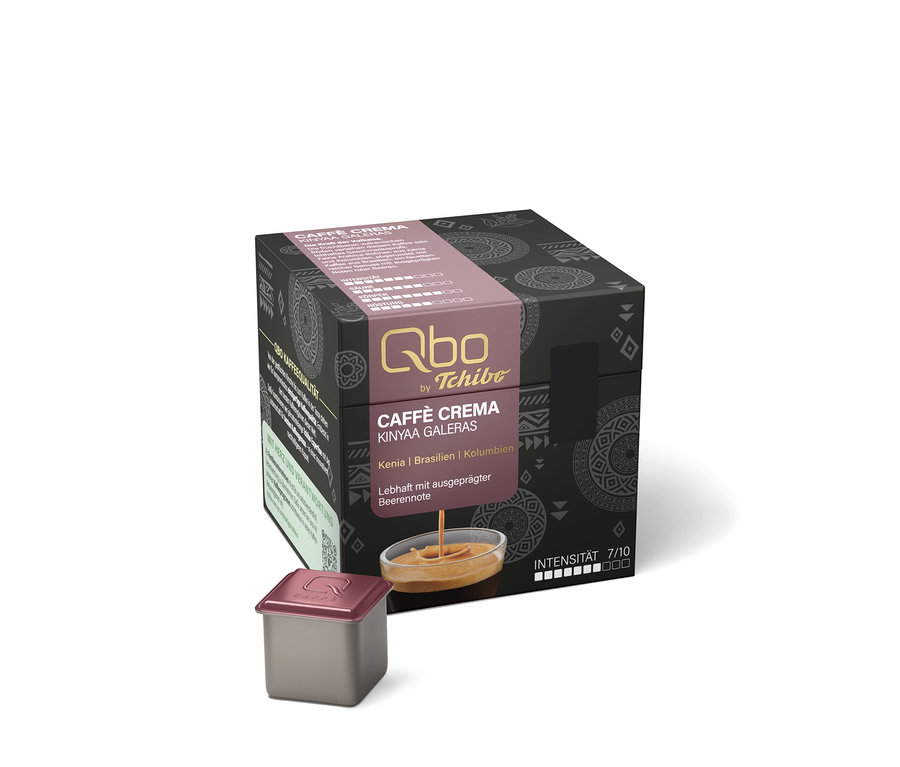 Dunkelgraue Packung Qbo by Tchibo Caffè Crema Kinyaa Galeras Kaffeekapseln mit rosafarbener Banderole, die "Kenia | Brasilien | Kolumbien" und "Lebhaft mit ausgeprägter Beerennote" zeigt. Davor liegt eine einzelne graue Kapsel mit rosafarbenem Deckel.