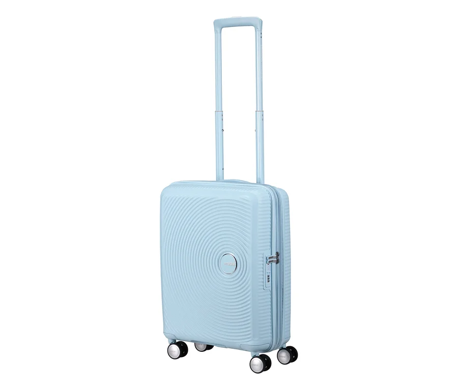 American Tourister Hartschalen-Koffer Soundbox Spinner in Pastellblau, klein, mit ausgefahrenem Teleskopgriff und vier Rollen.