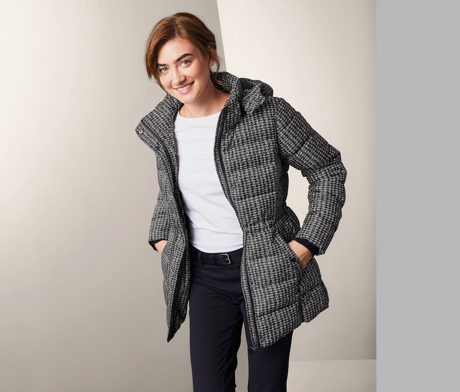 Frau posiert in Outdoorjacke mit Kapuze.