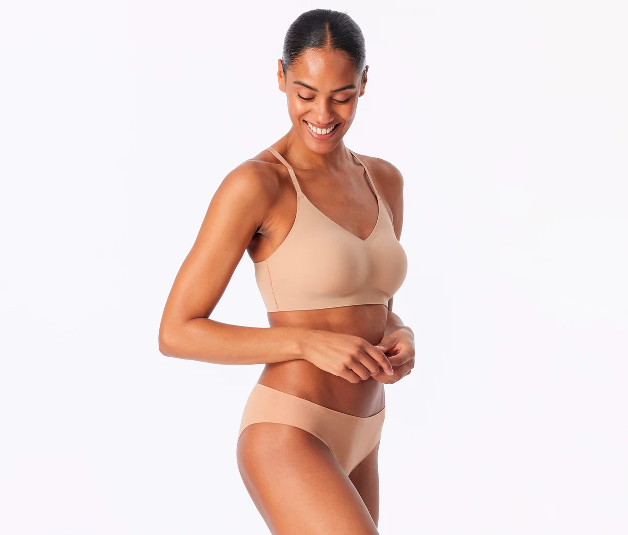 Lächelnde Frau trägt ein SCHIESSER Invisible Bustier mit Pads in Maple und passende Slips.