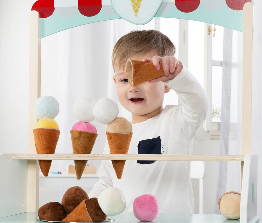 Ein Junge spielt mit einem roba Eisstand mit 9-teiligem Zubehör.