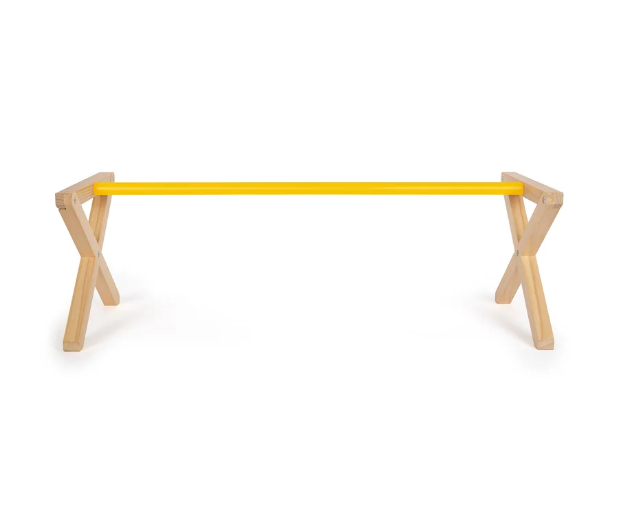 Ein gelber Cavaletti-Balken liegt zwischen zwei Holzständern auf einem weißen Hintergrund.