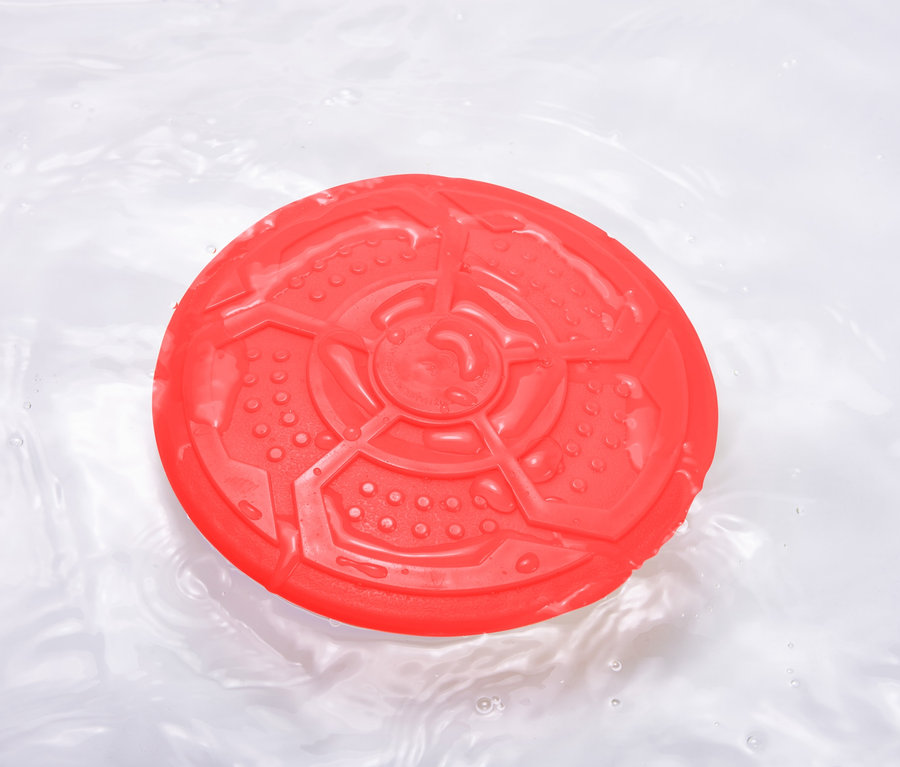 Eine rote Hunde-Wurfscheibe schwimmt im Wasser.