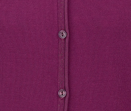 Detail einer fuchsiafarbenen Feinstrickjacke mit zwei Knöpfen.